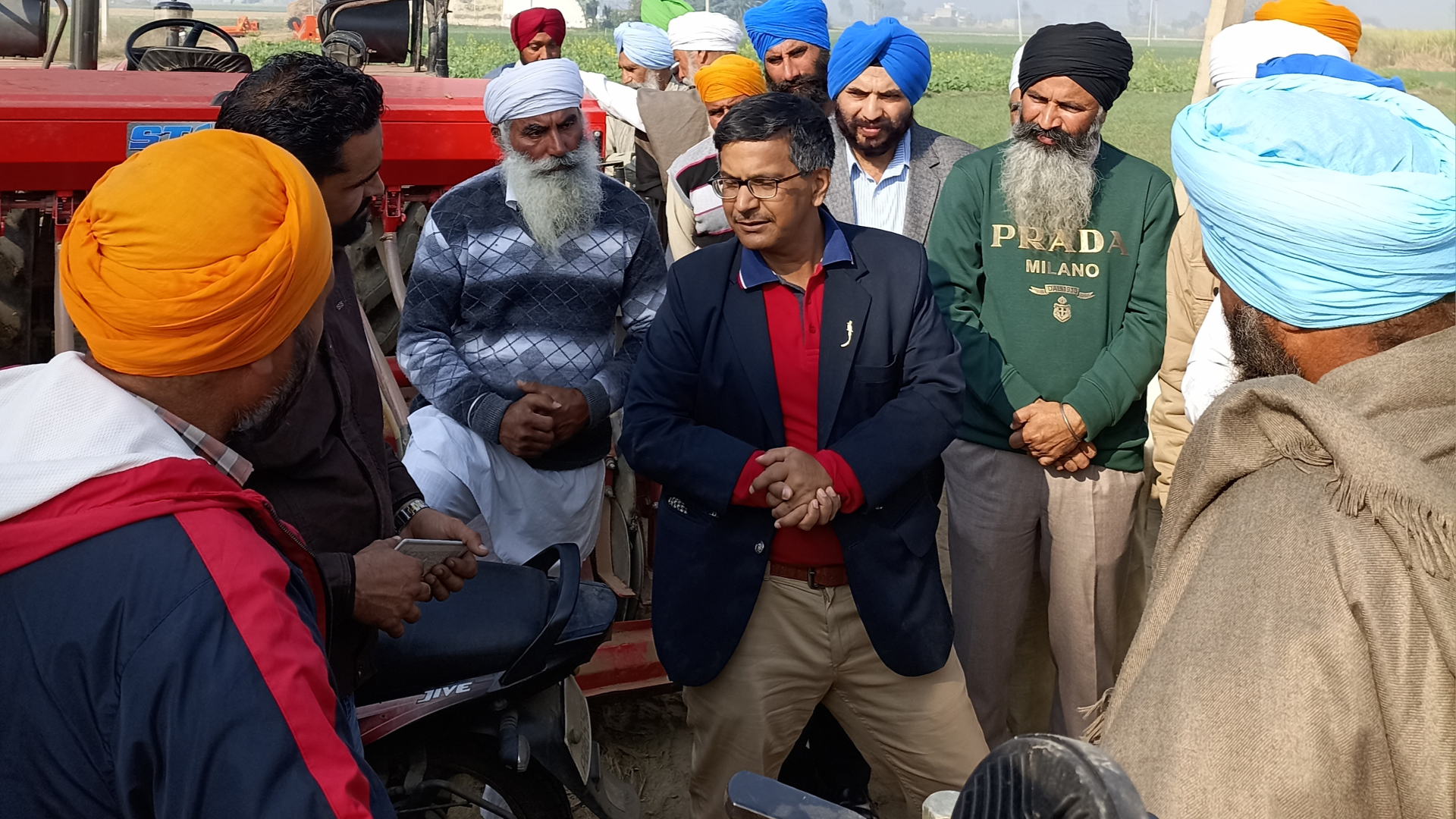 People gathered by a tractor 